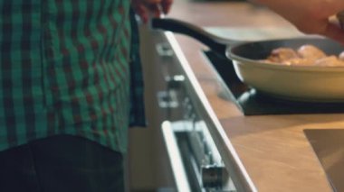 Baba ekose gömlekli tavuk drumsticks onun çocuklar için sağlıklı yemek için yerli ev mutfakta pişiyor