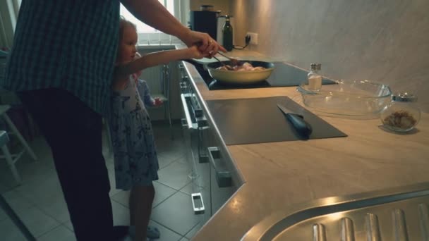 Otec v kostkované košili je vaření kuřecí Paličky pro jeho děti zdravé večeře v domácí domácí kuchyně