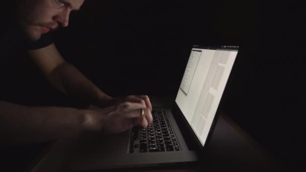 Criminalité fédérale. Homme, pirate prétendument criminel, tente de pirater le serveur du gouvernement la nuit. Ordinateur portable avec disposition russe .