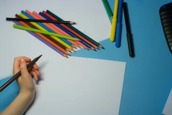 Little girl with pencils and felt-tip pens is writing a letter to Santa