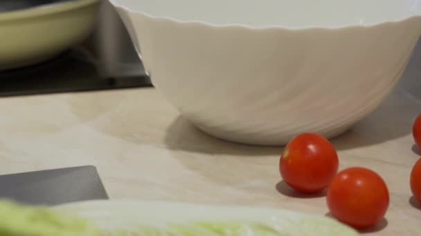 Otec v pruhované tričko se vaří bio zeleninový salát s cherry rajčátky a čínské zelí pro své děti k večeři v domácí domácí kuchyně