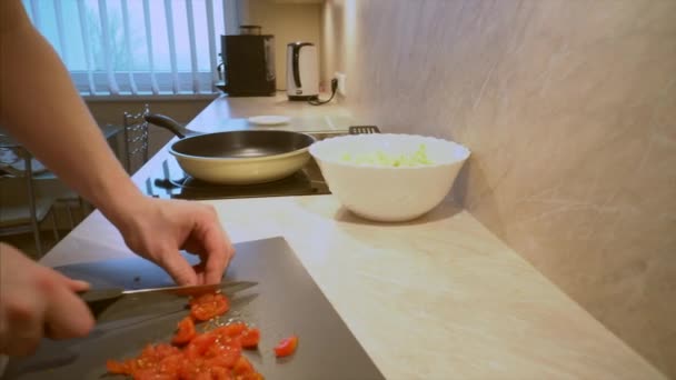 Father in a striped shirt is cooking fresh organic vegetable salad with Cocktail Tomatoes and Chinese Cabbage for his children for dinner in the domestic home kitchen — Stock Footage Father Striped Shirt Cooking Fresh Organic Vegetable Salad Cocktail Tomatoes Stock Video