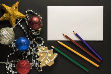 Noel kartı dekorasyon, kalemler ve karanlık bir arka plan üzerinde beyaz kağıdın