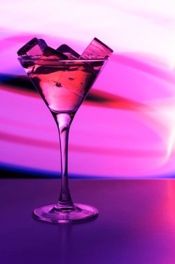 Bir gece kulübü neon ışık bir içki ve buz küpleri ile kokteyl cam