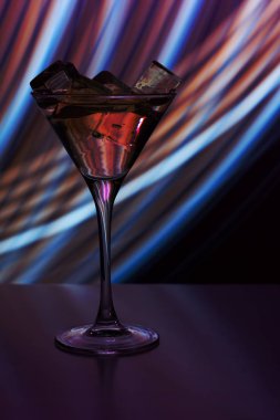 Bir gece kulübü neon ışık bir içki ve buz küpleri ile kokteyl cam