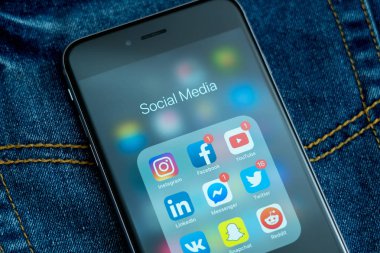 Tallinn / Estonya - 01/20/2019: sosyal medya simgeler ile siyah elma iphone: instagram, youtube, reddit, facebook, twitter, snapchat uygulama üstünde perde. Sosyal medya simgeler. Denim kot arka plan