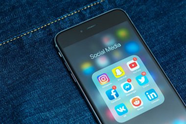 Tallinn / Estonya - 01/20/2019: sosyal medya simgeler ile siyah elma iphone: instagram, youtube, reddit, facebook, twitter, snapchat uygulama üstünde perde. Sosyal medya simgeler. Denim kot arka plan