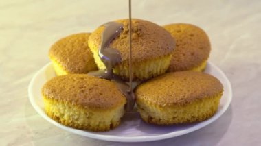 Fırından yeni çıkmış dökülen kek Çikolata sosu bir plaka üzerinde erimiş. Damlama çikolata. Mermer arka plan ve doğal aydınlatma iç mutfakta. Organik doğal maddeler.