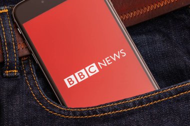 Tallinn / Estonia - 02/22/2019: haber medya Bbc News ekranda kırmızı logolu siyah telefon. Haber medya simgesi. Denim kot arka plan