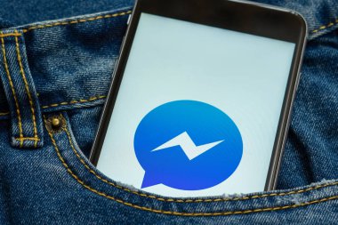 Sosyal medya Facebook Messenger ekrandaki logolu siyah telefon. Sosyal medya simge. Denim kot arka plan.