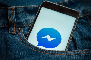 Sosyal medya Facebook Messenger ekrandaki logolu siyah telefon. Sosyal medya simge. Denim kot arka plan.