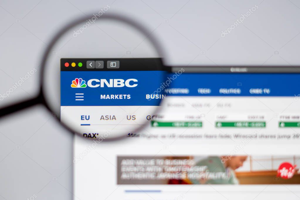 New York, USA - March 26, 2019: News media CNBC website homepage. CNBC News logo visible  through a magnifying glass.