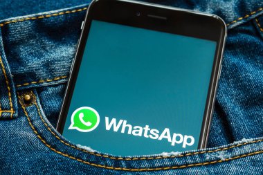 New York/ABD-02/23/2019: ekranda sosyal medya WhatsApp logosu ile siyah telefon. Sosyal medya simgesi. Denim kot arka plan. Pazarlama veya iş konsepti için kullanılabilir.