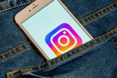 Tallinn / Estonya - 19 Mayıs 2019: Ekranda sosyal medya Instagram logosu bulunan beyaz telefon. Sosyal medya simgesi. Denim kot arka plan. Haber medyası veya pazarlama konsepti için illüstrasyon.