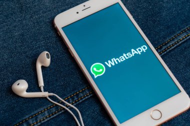 Tallinn/Estonya - 19 Mayıs 2019: Ekranda sosyal medya Whatsapp logolu beyaz iphone. Sosyal medya simgesi. Denim kot arka plan. Pazarlama veya iş konsepti.
