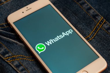 Tallinn/Estonya - 19 Mayıs 2019: Ekranda sosyal medya Whatsapp logolu beyaz iphone. Sosyal medya simgesi. Denim kot arka plan. Pazarlama veya iş konsepti.