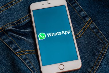 Tallinn/Estonya - 19 Mayıs 2019: Ekranda sosyal medya Whatsapp logolu beyaz iphone. Sosyal medya simgesi. Denim kot arka plan. Pazarlama veya iş konsepti.