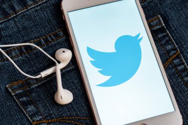 Tallinn/Estonya - 19 Mayıs 2019: Ekranda sosyal medya Twitter logosu bulunan beyaz iphone. Sosyal medya simgesi. Denim kot arka plan. Haber medyası için pazarlama konsepti veya illüstrasyon.