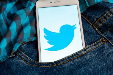 Tallinn/Estonya - 19 Mayıs 2019: Ekranda sosyal medya Twitter logosu bulunan beyaz iphone. Sosyal medya simgesi. Denim kot arka plan. Haber medyası için pazarlama konsepti veya illüstrasyon.