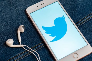 Tallinn/Estonya - 19 Mayıs 2019: Ekranda sosyal medya Twitter logosu bulunan beyaz iphone. Sosyal medya simgesi. Denim kot arka plan. Haber medyası için pazarlama konsepti veya illüstrasyon.