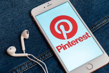 Tallinn/Estonya - 19 Mayıs 2019: Ekranda sosyal medya Pinterest logolu beyaz iphone. Sosyal medya simgesi. Denim kot arka plan. Haber medyası için pazarlama konsepti veya illüstrasyon.