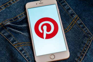 Tallinn/Estonya - 19 Mayıs 2019: Ekranda sosyal medya Pinterest logolu beyaz iphone. Sosyal medya simgesi. Denim kot arka plan. Haber medyası için pazarlama konsepti veya illüstrasyon.