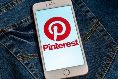 Tallinn/Estonya - 19 Mayıs 2019: Ekranda sosyal medya Pinterest logolu beyaz iphone. Sosyal medya simgesi. Denim kot arka plan. Haber medyası için pazarlama konsepti veya illüstrasyon.