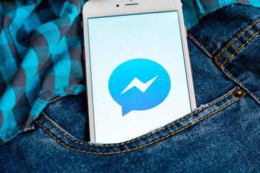 Tallinn/Estonya - 19 Mayıs 2019: Ekranda sosyal medya Facebook Messenger logosu bulunan beyaz iphone. Sosyal medya simgesi. Denim kot arka plan. Pazarlama veya iş konsepti.