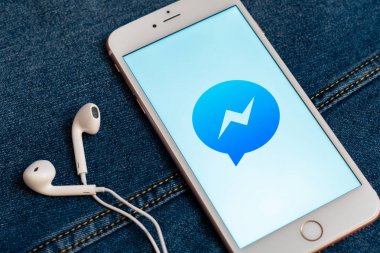 Tallinn/Estonya - 19 Mayıs 2019: Ekranda sosyal medya Facebook Messenger logosu bulunan beyaz iphone. Sosyal medya simgesi. Denim kot arka plan. Pazarlama veya iş konsepti.