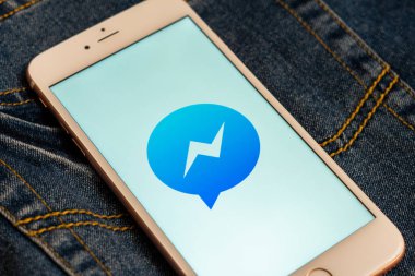 Tallinn/Estonya - 19 Mayıs 2019: Ekranda sosyal medya Facebook Messenger logosu bulunan beyaz iphone. Sosyal medya simgesi. Denim kot arka plan. Pazarlama veya iş konsepti.