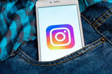 Tallinn / Estonya - 19 Mayıs 2019: Ekranda sosyal medya Instagram logosu bulunan beyaz telefon. Sosyal medya simgesi. Denim kot arka plan. Haber medyası veya pazarlama konsepti için illüstrasyon.