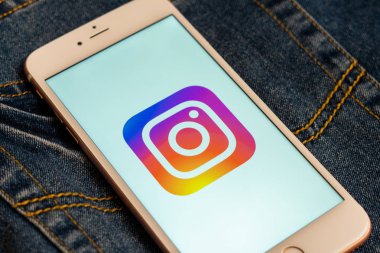 Tallinn / Estonya - 19 Mayıs 2019: Ekranda sosyal medya Instagram logosu bulunan beyaz telefon. Sosyal medya simgesi. Denim kot arka plan. Haber medyası veya pazarlama konsepti için illüstrasyon.