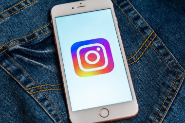 Tallinn / Estonya - 19 Mayıs 2019: Ekranda sosyal medya Instagram logosu bulunan beyaz telefon. Sosyal medya simgesi. Denim kot arka plan. Haber medyası veya pazarlama konsepti için illüstrasyon.