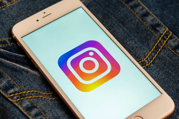 Tallinn / Estonya - 19 Mayıs 2019: Ekranda sosyal medya Instagram logosu bulunan beyaz telefon. Sosyal medya simgesi. Denim kot arka plan. Haber medyası veya pazarlama konsepti için illüstrasyon.