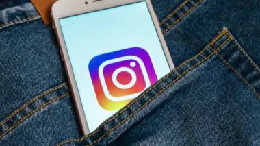 Tallinn / Estonya - 19 Mayıs 2019: Ekranda sosyal medya Instagram logosu bulunan beyaz telefon. Sosyal medya simgesi. Denim kot arka plan. Haber medyası veya pazarlama konsepti için illüstrasyon.