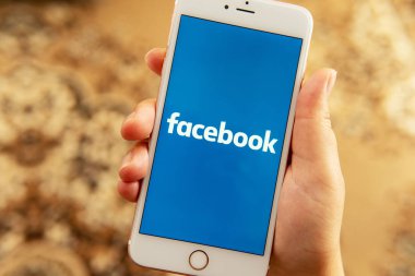 Sosyal medya Facebook logosu ile Apple telefon ile Kadın el 