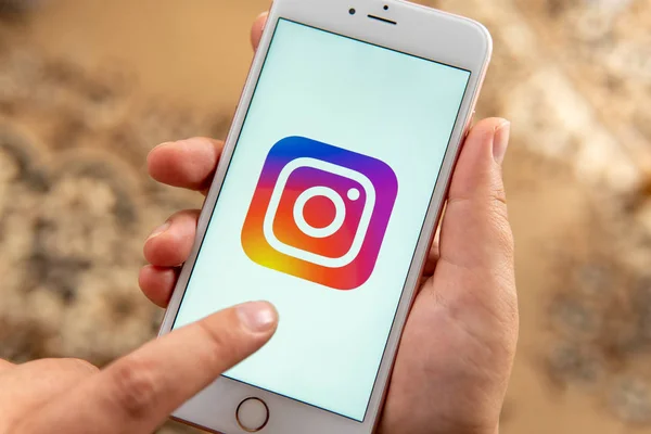 Жіноча рука з яблуком телефон з логотипом соціальних медіа Instagram — стокове фото