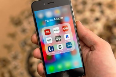 Farklı Haber medya simgeleri ile Siyah iphone ile El