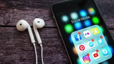 New York / Usa - 12 Nisan 2019: Siyah Elma iPhone ahşap arka planda, sosyal medya uygulamalarının simgeleri ekranda ve sayaçlarda. Sosyal medya simgeleri. Pazarlama ya da iş konsepti