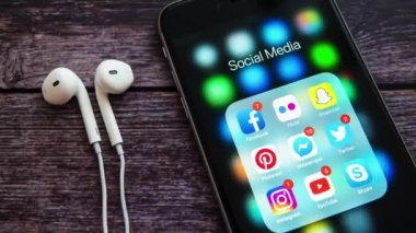 New York / Usa - 12 Nisan 2019: Siyah Elma iPhone ahşap arka planda, sosyal medya uygulamalarının simgeleri ekranda ve sayaçlarda. Sosyal medya simgeleri. Pazarlama ya da iş konsepti