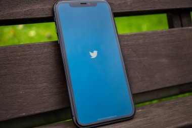Tallinn / Estonya - 1 Eylül 2020: Ekranda sosyal medya Twitter logosu olan siyah iPhone. Sosyal medya ikonu. Eski ahşap arka plan. Haber medyası için pazarlama kavramı veya illüstrasyon.