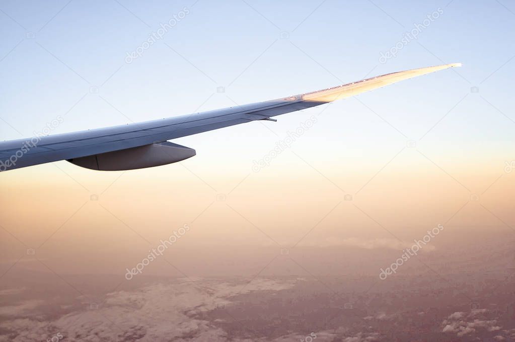 Airplane Wing Flying over a Hazy Red Landscape