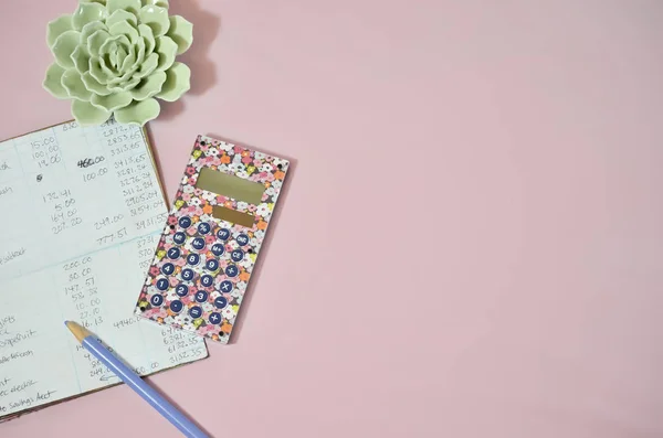 Pembe bir arka plan üzerinde hesap makinesiyle çek defteri