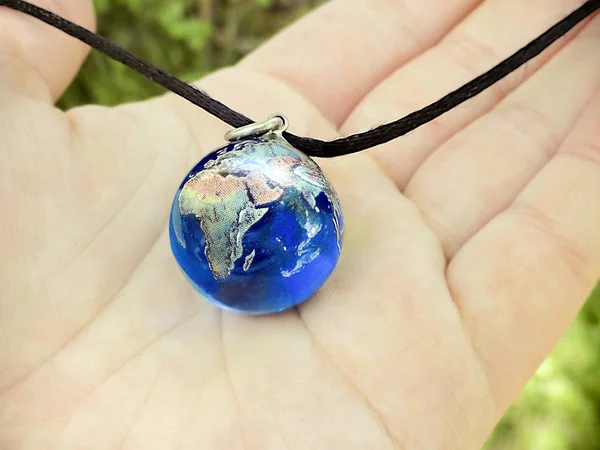 Mavi bir dünya kolye onun avucunda tutan el