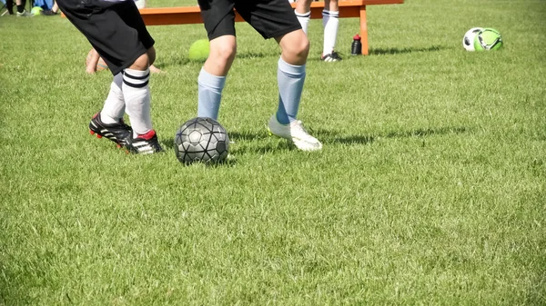 Feet Kicking Ball during a Youth Soccer Game