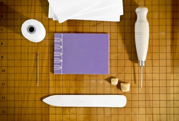 Ahşap Yüzeyde Küçük Mor Defterli Kitap Ciltleme Malzemeleri