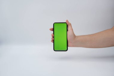 Beyaz arka planda bir kadının eli dikey olarak telefonu tutuyor. Yeşil Ekran