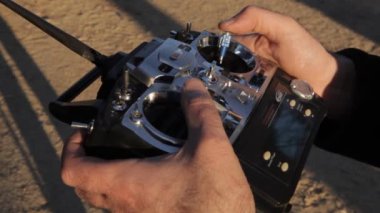 Drone radio control at the sunset. Someone with a RC controler is moving a drone, car, airplane  or some radio control vehicle at sunset.