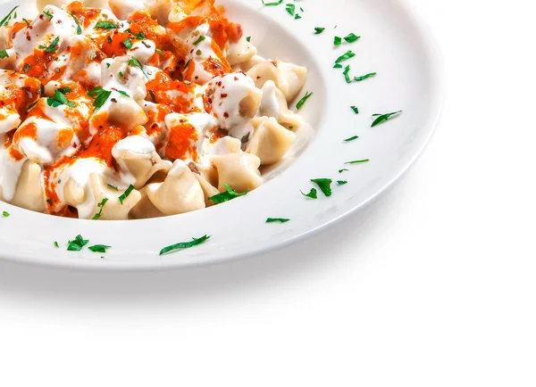 baharatlı sos ve kase beyaz zemin üzerine ekşi krema ile mantı