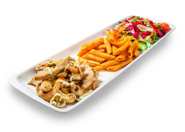 Gulaş ve beyaz arka plan üzerinde bir tabakta sebze ile makarna